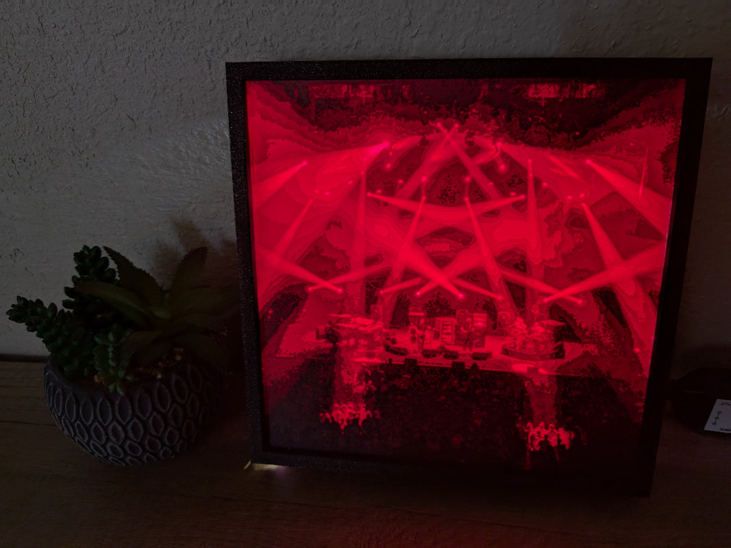 Illuminated Stash Project art piece showcasing a vibrant red glow of a live Phish concert in a framed display.