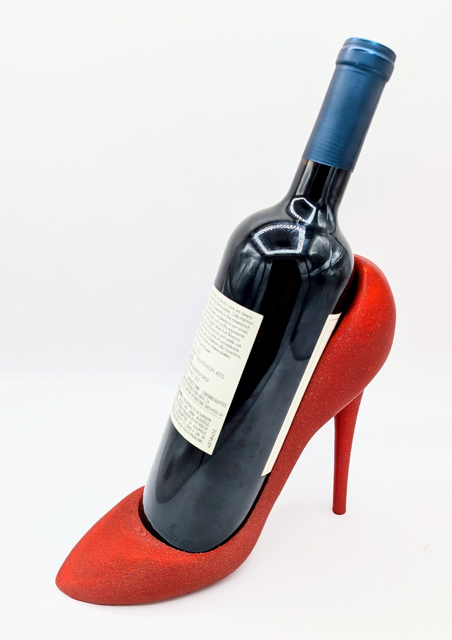 Red high-heel wine holder showcasing a wine bottle, adding a playful touch to home decor. Ideal for wine lovers and shoe enthusiasts.