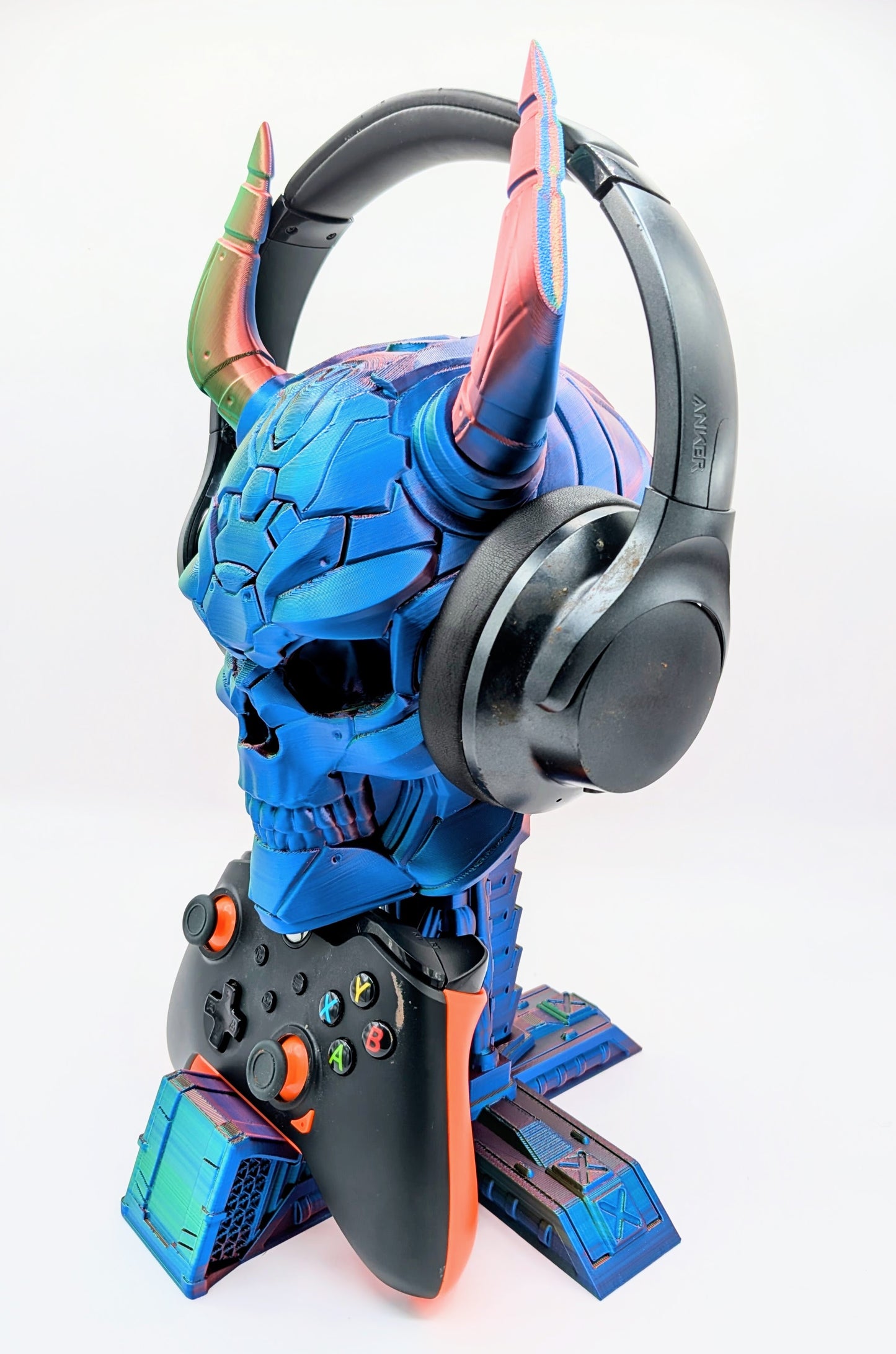 Demon skull display with headphones and game controller, perfect for gaming enthusiasts and collectors.