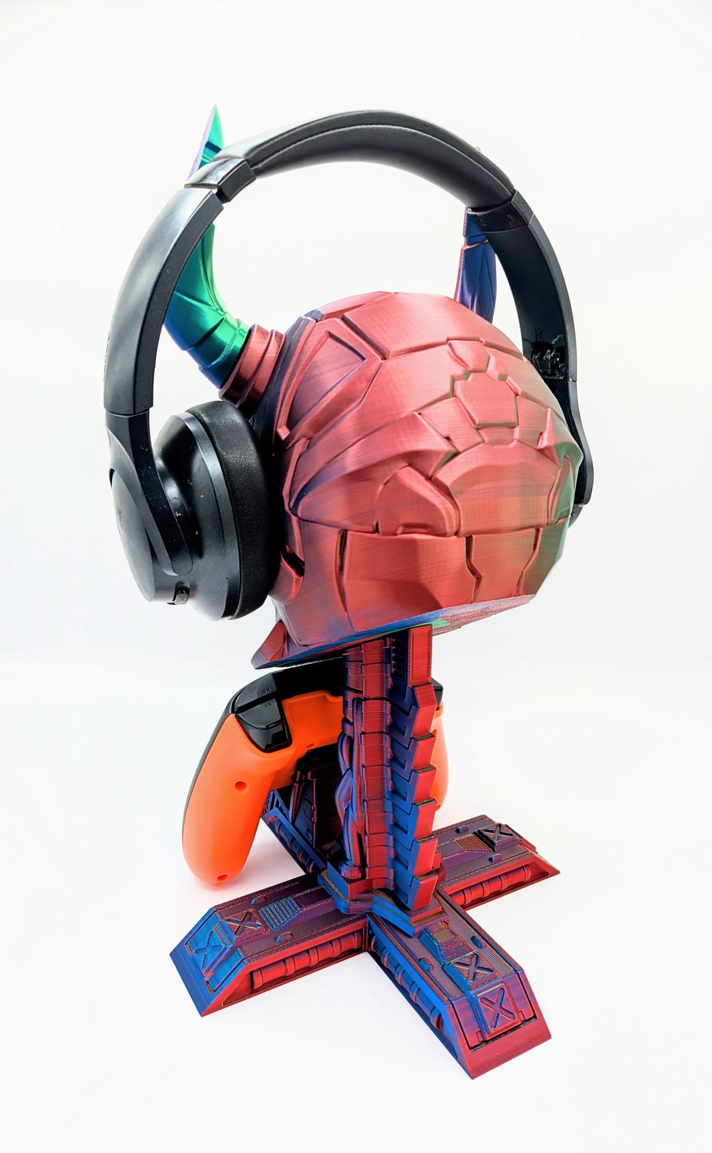 Demon skull headphone stand holding a game controller, colorful design with horns and detailed base, perfect for gamers.